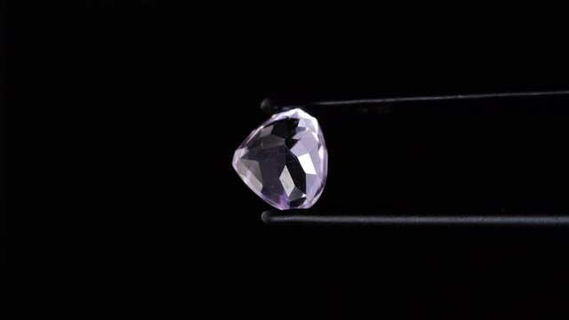 natural pink kunzite gemstone  in tweezer on the turn table