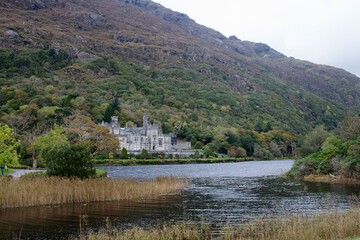 Fototapeta na wymiar Kylemore Abbey, home to the Sisters of the Benedictine Order in Ireland. Duchruach Mountain, on the northern shore of Lough Pollacappul, in the heart of the Connemara Mountains.