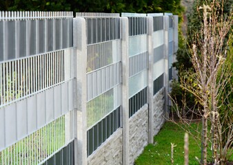 Garden fence made with decorative galvanized wire fence panels inserted in to the concrete columns.
