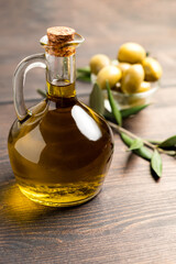 Extra virgin olive oil in a bottle, green olives and olive tree branches. healthy eating concept, basic products of the Mediterranean diet.