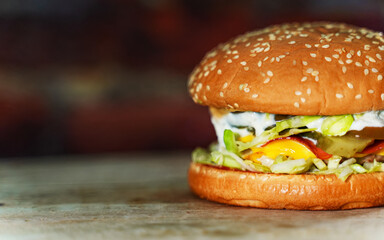 Rustic handmade hamburger on a brick wall background.