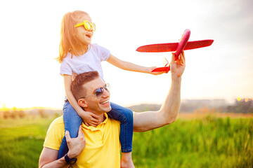 Happy father and daughter playing with plane