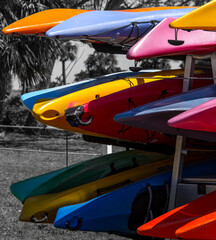  parts of colorful kayaks showing on a stand with black and white background.