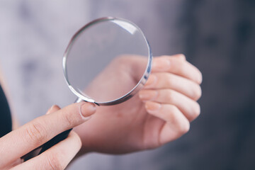 girl checks nails with a magnifying glass