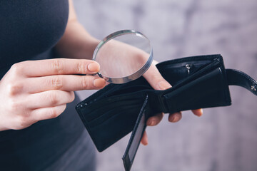 girl holding a magnifying glass and wallet