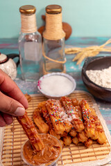 man's hand spreading arequipe to typical Spanish churros covered with colored sparks