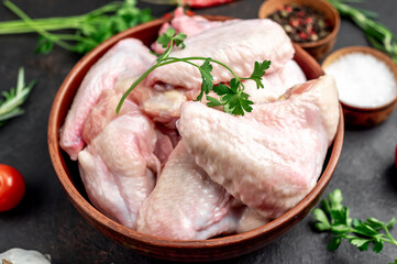 raw chicken wings with spices on a stone background