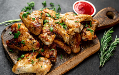 grilled chicken wings with spices on a stone background
