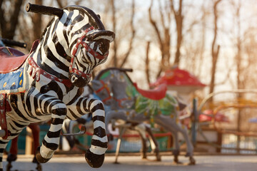 Soviet abandoned amusement park. Vintage carousel horses. A traditional fairground carousel