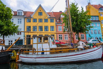 Fototapeta na wymiar Old wooden barge along a canal in Copenhagen, in the background historic buildings
