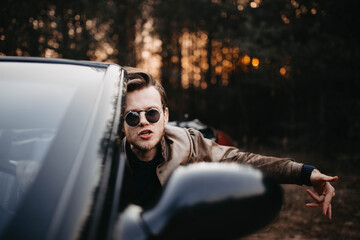 fashionable man in sunglasses in a convertible, pretentious driver.