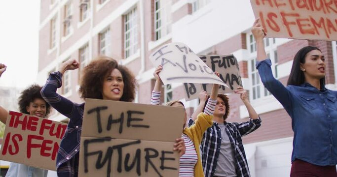 Diverse Group Of Men And Women Holding Placards Raising Fists Shouting During Protest