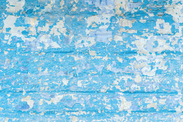 Fototapeta na wymiar Old cracked brick wall with blue peeling paint 