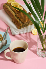 lemon poppy cupcake on a blue minimalistic plate on a pink background. Composition with hard shadows from the sun