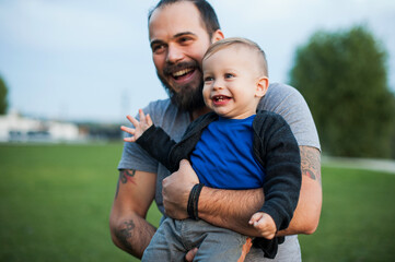 Happy father and his little son are having fun in the park. Beautiful family is spending time together outside.