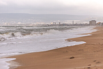 Deserted beaches of Feodosia in winter. Wide beach and storm at sea. A beach that is waiting for...