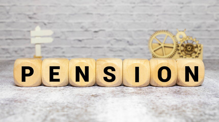 Wooden cubes with letters on the table in the office. Text PENSION. Financial concept.