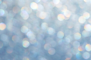 bright glitter background: bokeh effect from many colored lights on frozen glass, toning
