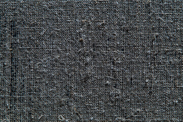 dark creative background: reverse side of black-primed linen canvas, uneven lighting, color toning