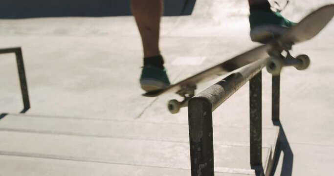 Low section of caucasian man riding and jumping on skateboard on sunny day