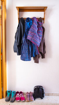 Vertical Shot Of A Coat Rack Full Of Clothes Of The Family Members