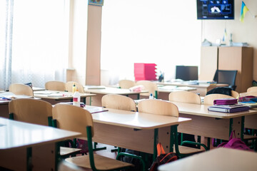 Empty school class. children left classroom during quarantine. Abandoned books and backpacks.