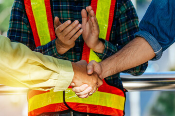 Partnership. team of construction worker shaking hand with customer after finishing up business meeting to greeting start up project contract at construction site, business and contractor concept