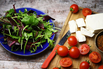 Cooking a healthy salad. Salad, cherry tomatoes, feta.