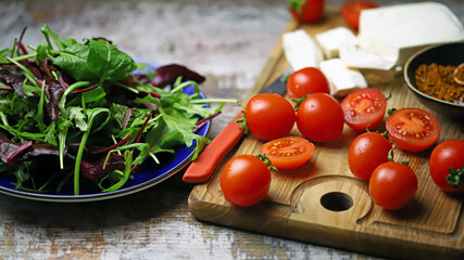 Cooking a healthy salad. Salad, cherry tomatoes, feta.