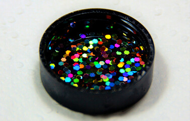 Holographic glitter on the lens of a camera isolated on white background