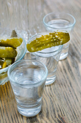 Vodka in a glass and pickled cucumber