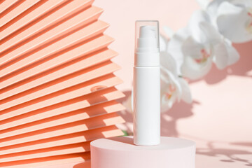 Cosmetic cream dispenser product mockup presentation on podium pedestal and chinese paper fan pink floral background. Face cream moisturizer showcase, luxury skincare spa cosmetics. Minimal template