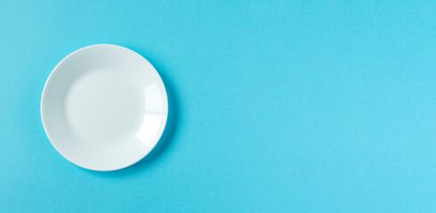 White plate on light blue background.  水色背景上の白いお皿