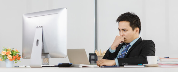 Adult asian businessman office people sitting at working desk and using computer and look at...