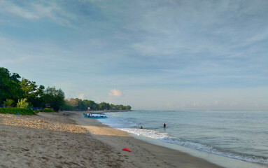 Obraz premium A woman walking around Kuta Beach Bali and playing with the doga.