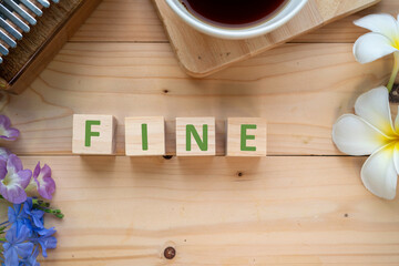 Positive Words Vocabulary  concept, FINE word cube wooden with Coffee mugs, Kalimba and small flowers on the wooden background, start your work day refreshed.