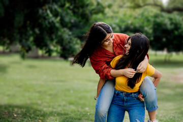 Authentic people. candid portrait Female couple playing enjoying a day in the park, smiling...