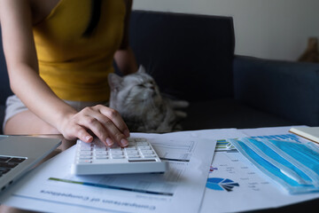 casual woman in yellow dress making audit while work from home with her cat.