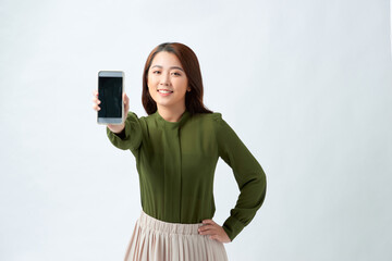 Young beautiful woman in casual style holding phone looking at camera and showing phone display.