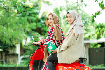 happy muslim girls riding scooter enjoy summer vacation