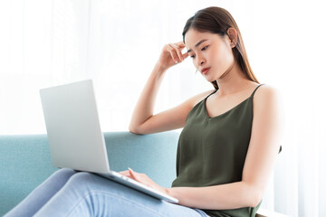 Asian woman is using laptop with worried expression