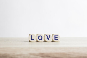 A word "Love" on a wooden table over the light background.