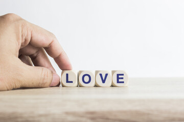 A word "Love" on a wooden table over the light background.