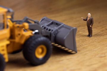 重機の前に立って制止するビジネスマン