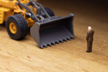 重機の前に立って制止するビジネスマン