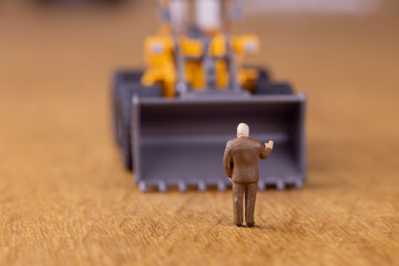 重機の前に立って制止するビジネスマン