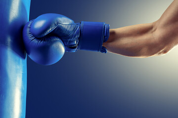 Strong boxer hand in a blue boxing glove.