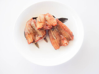 Crispy snakehead fish in a golden yellow white plate from top view.