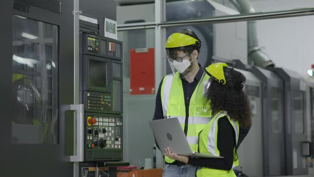 Electrical engineer check machine equipment. Wear protective equipment. Safety hard hat to prevent accidents. Face Mask to prevent dust, COVID-19 in operation Or industrial Factory.