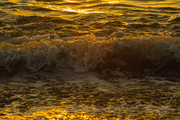 The Golden sea waves texture background at sunset